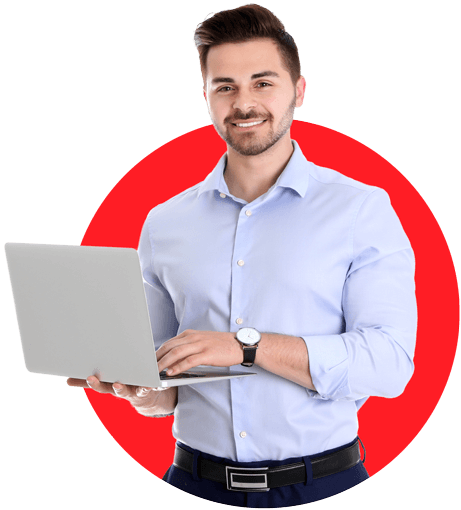 Young man holding laptop, smiling confidently in a blue shirt.